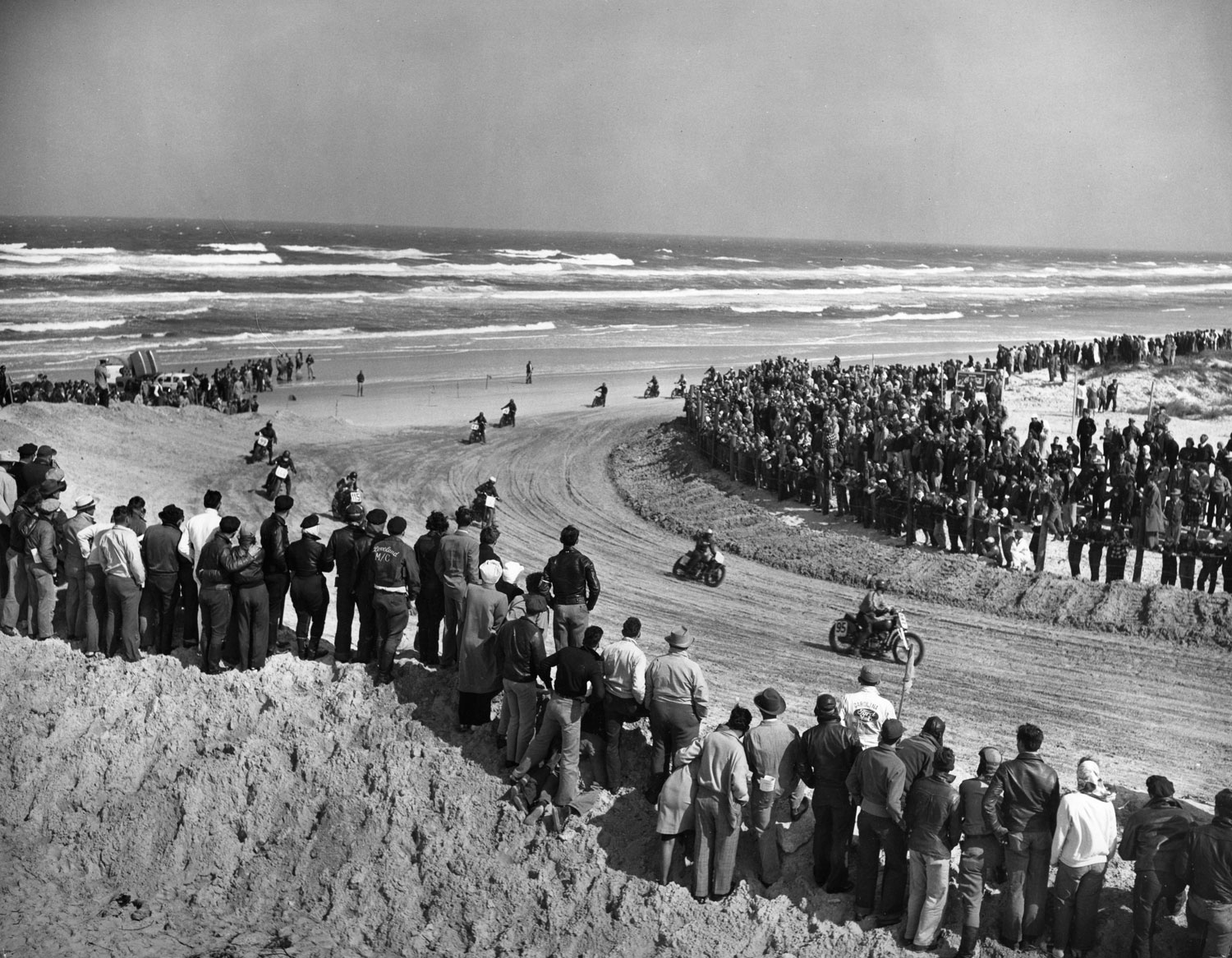 Photo of spectators standing on the north sand bank of the 1948 Daytona 200